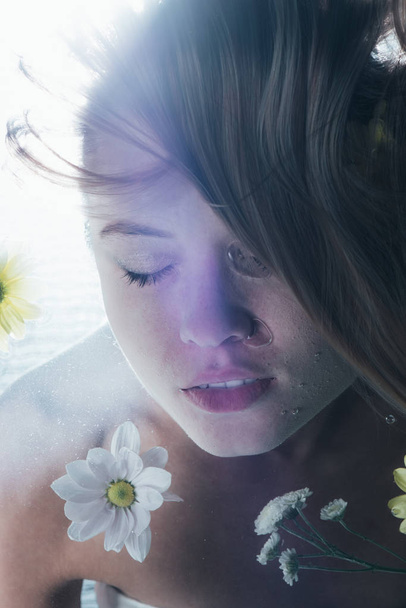 cropped view of beautiful girl posing underwater with white flowers - Photo, Image