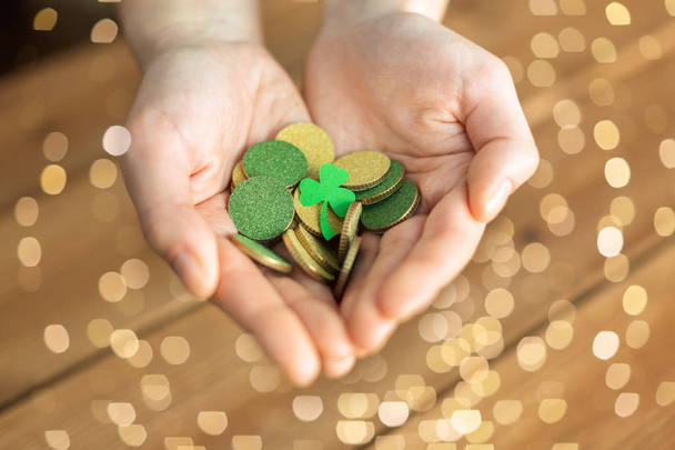 hands with golden coins and shamrock leaf - Photo, image
