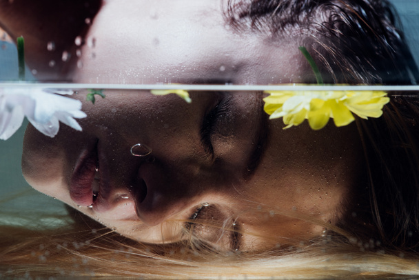 close up of beautiful girl posing over water with flowers - Valokuva, kuva