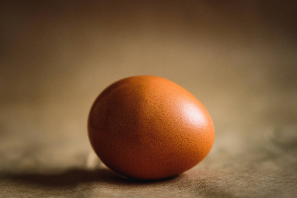 Fotografie hnědé kuřecí vejce na hnědém pozadí. - Fotografie, Obrázek