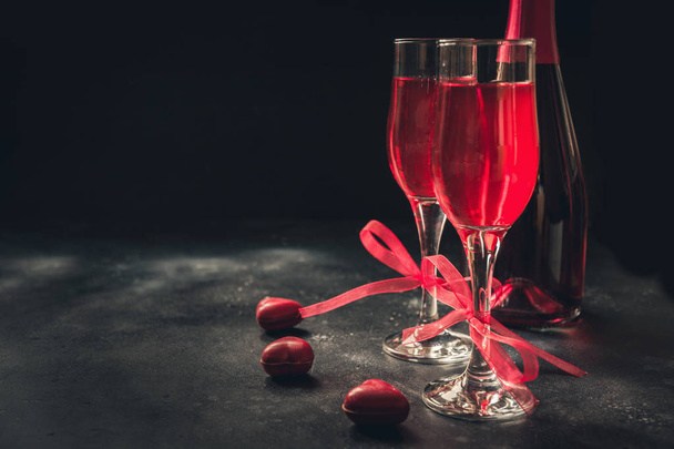Walentynki i kartkę z życzeniami urodzinowymi czerwony szampan i cukierki serca na czarnym tle. Miejsca na tekst i pozdrowienia. - Zdjęcie, obraz
