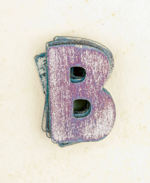 ένα σωρό των παλαιών ζωγραφισμένα ξύλινα γράμματα Β s στο παλιό φθαρμένο χαρτί - Φωτογραφία, εικόνα