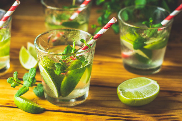 Fresh alcoholic cocktail with lime, ice and mint, mojito cocktail in a bur on a rustic table, selective focus, shallow depth of the field. - Фото, зображення