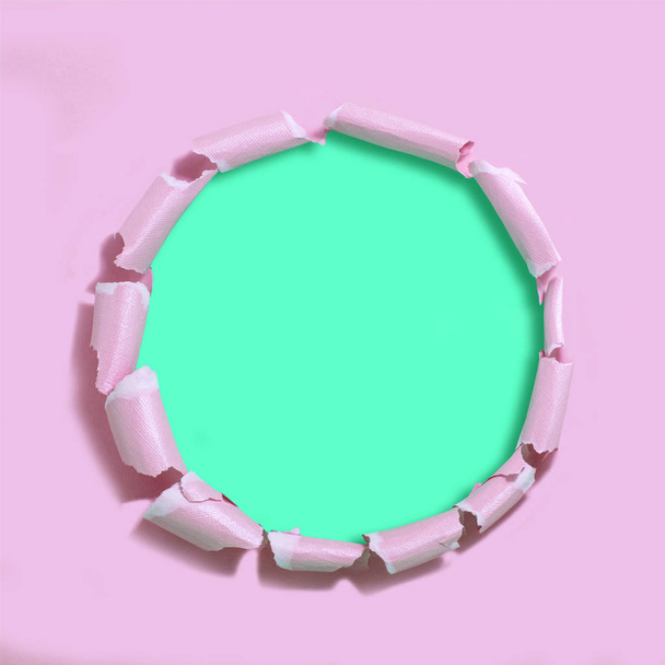 Pink torn paper with hole against green background. Minimal abstract colorful background - Photo, Image
