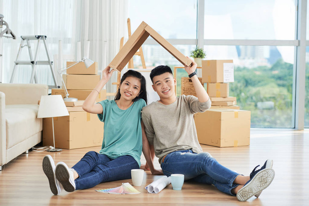 jovem asiático homem e mulher sentado no chão do novo apartamento
 - Foto, Imagem