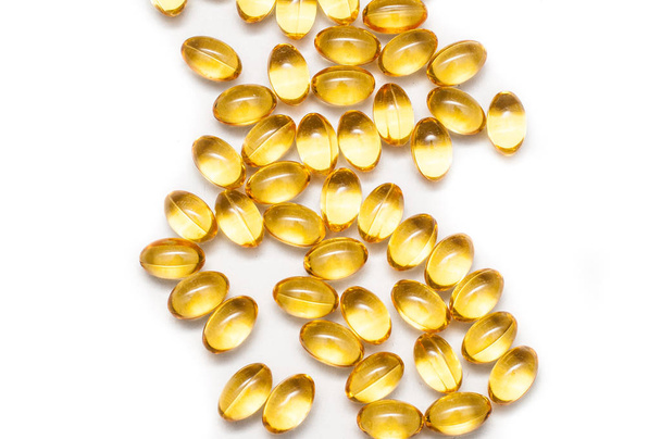 Close up of food supplement oil filled capsules suitable for: fish oil, omega 3, omega 6, omega 9, evening primrose, borage oil, flax seeds oil, vitamin A, vitamin D, vitamin D3, vitamin E. - Zdjęcie, obraz