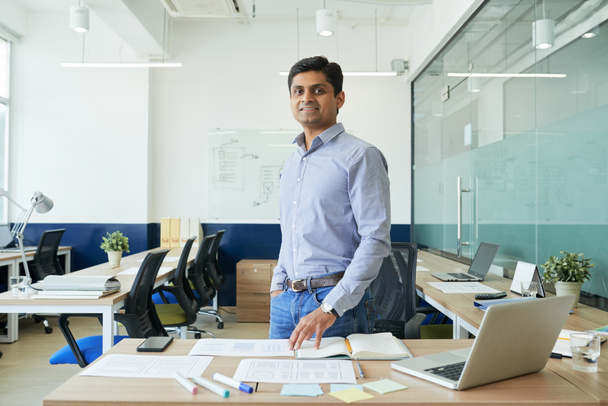 Portrait of happy Indian UX designer standing in modern office - Foto, immagini