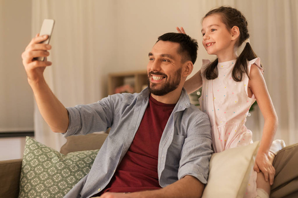 father and daughter taking selfie at home - Φωτογραφία, εικόνα