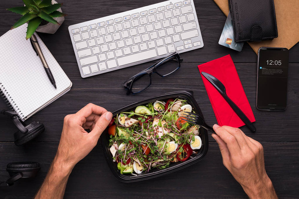 Geschäftsmann genießt gesunden Salat am Schreibtisch - Foto, Bild