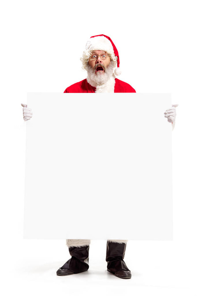 Happy Santa Claus pointing on blank advertisement banner background with copy space. Smiling Santa Claus pointing in white blank sign - Fotoğraf, Görsel