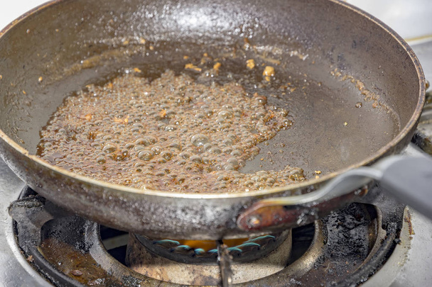 sugar caramelizing in a frying pan at gas stove in kitchen - Photo, Image