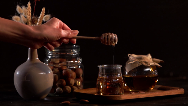 oříznutý pohled ženy dávat dřevěnou tyčí v viskózní medu  - Záběry, video