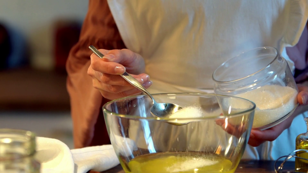 повільний рух жіночого кухаря додавання цукру до збитих яєць у мисці
 - Кадри, відео