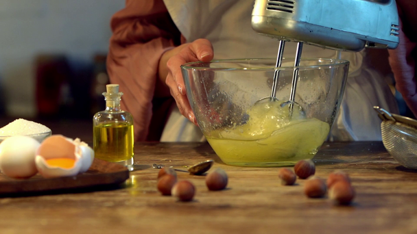 жіночі яйця готують у скляній мисці з мікшером за дерев'яним столом
 - Кадри, відео