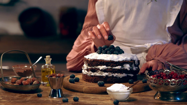 zwolnionym tempie kobieta kucharz dekorowanie ciasta z jagodami - Materiał filmowy, wideo