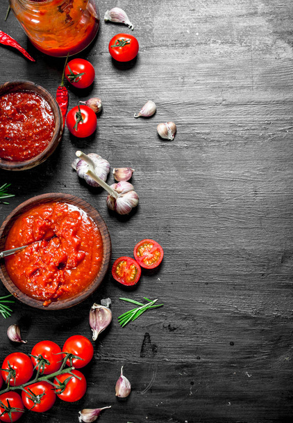 Tomato sauce with garlic and herbs. On black background. - 写真・画像