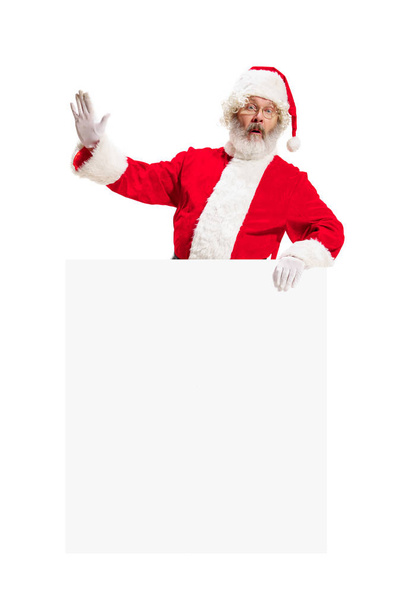 Happy Santa Claus pointing on blank advertisement banner background with copy space. Smiling Santa Claus pointing in white blank sign - Photo, Image