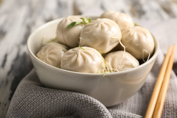 Bowl with tasty Chinese dumplings on table - Foto, afbeelding