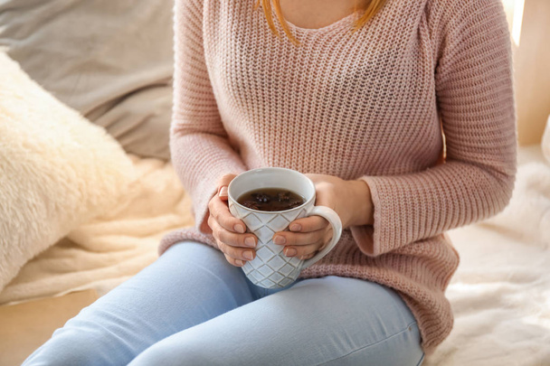 Jovem mulher bebendo café quente em casa
 - Foto, Imagem