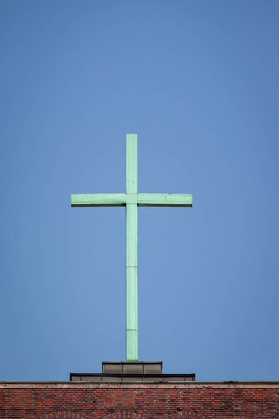 Cruz en la parte superior de una iglesia frente a un cielo azul
 - Foto, imagen