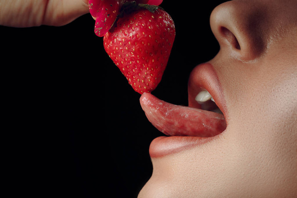 Sexy image of red lips kissing strawberry. Passion and desire. Perfect skin. - Photo, Image