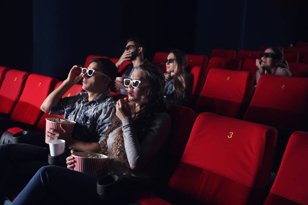 Young couple watching movie in cinema - Фото, изображение