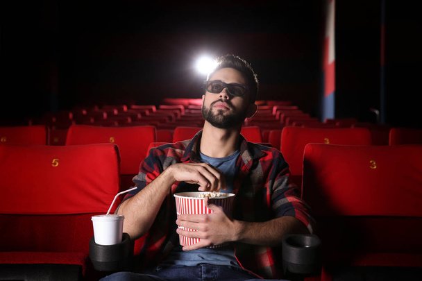 Young man watching movie in cinema - Foto, imagen