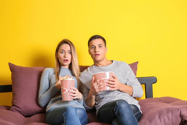 Jeune couple avec pop-corn regarder le film tout en étant assis sur le lit
 - Photo, image