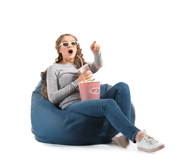 Young woman with popcorn watching movie on white background - Foto, immagini