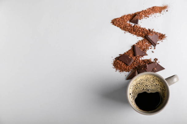 Komposition mit Tasse heißen Kaffee und Schokolade auf weißem Hintergrund - Foto, Bild