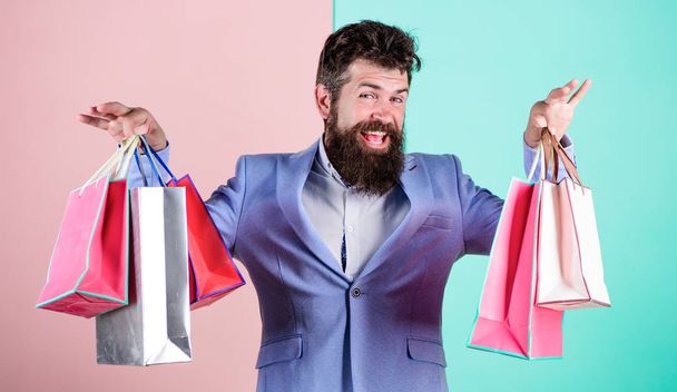 Man bearded hipster businessman formal suit carry paper shopping bags. Ready for holiday. Buy gifts for everyone. Buy gifts in advance. Enjoy shopping black friday. Hipster shopping with discount - Foto, Imagem