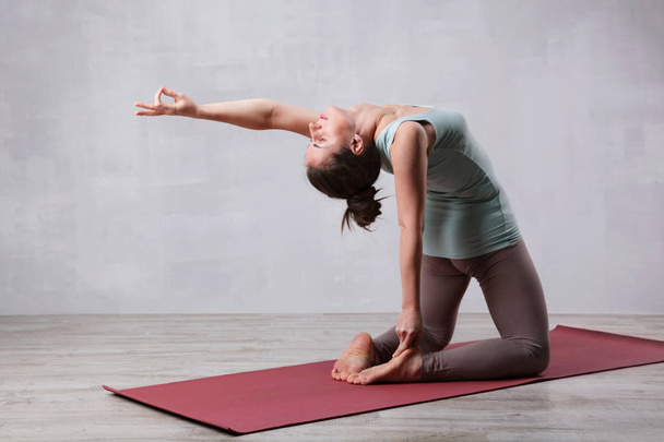 Beautiful woman practicing yoga in living room - Foto, Bild