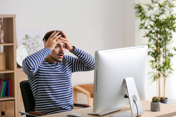 Емоційний молодий чоловік після програшу комп'ютерної гри вдома
 - Фото, зображення