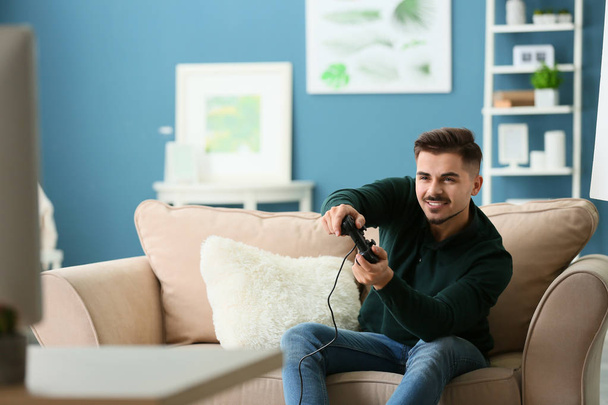 Young man playing video game at home - Fotoğraf, Görsel