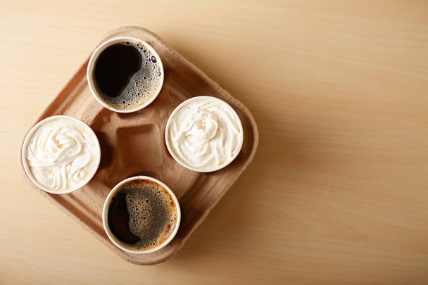 Paper cups with tasty coffee on wooden table - Photo, Image