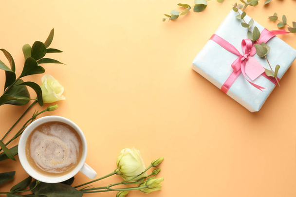 Composition with gift box, flowers and cup of coffee on color background - Valokuva, kuva