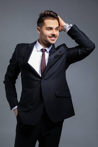 Stylish businessman on grey background - Foto, imagen