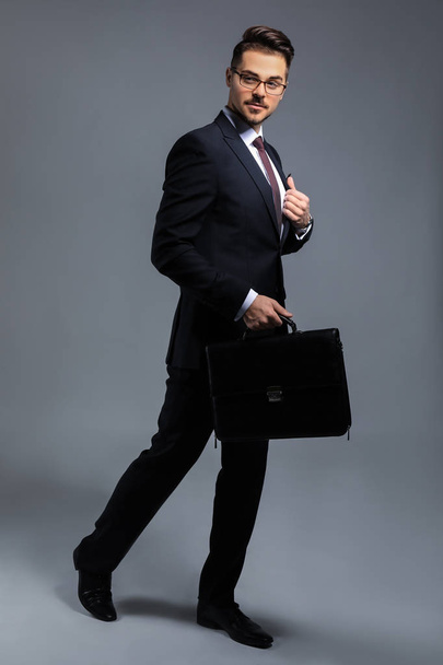 Stylish businessman on grey background - Фото, зображення