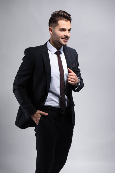 Stylish businessman on grey background - Фото, зображення
