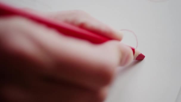 Mano derecha dibujando corazón rojo a lápiz para el amor en el día de San Valentín. Pintura a mano sobre el corazón de San Valentín en la tarjeta hecha a mano como símbolo romántico del amor. Preparación de regalo de San Valentín para persona adorada
 - Imágenes, Vídeo