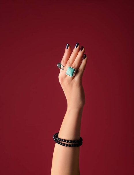 Hand of beautiful young woman with stylish bijouterie on color background - Foto, Bild