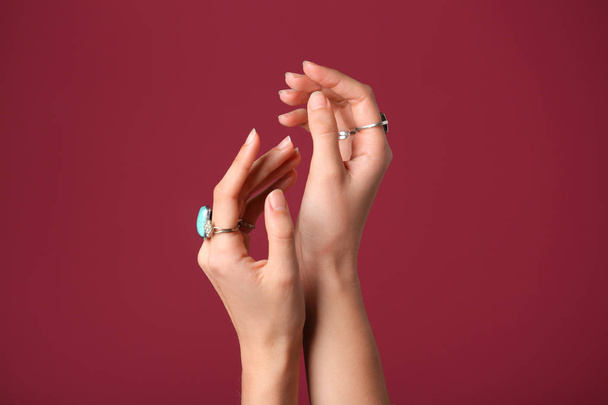 Mains de belle jeune femme avec bijouterie élégant sur fond de couleur
 - Photo, image