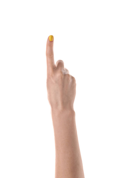 Vrouwelijke hand met opgeheven wijsvinger op witte achtergrond - Foto, afbeelding