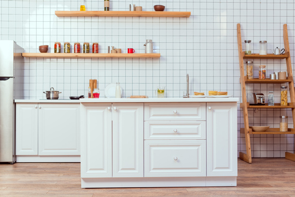 moderne keukenontwerp met witte meubels en tegel op achtergrond - Foto, afbeelding