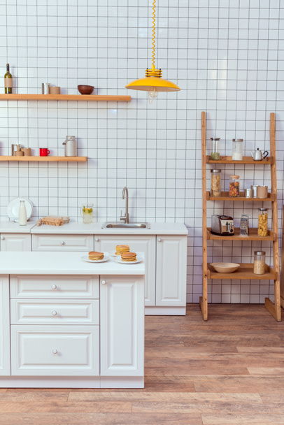 modern kitchen design with wooden shelves and white tile on background - Foto, afbeelding