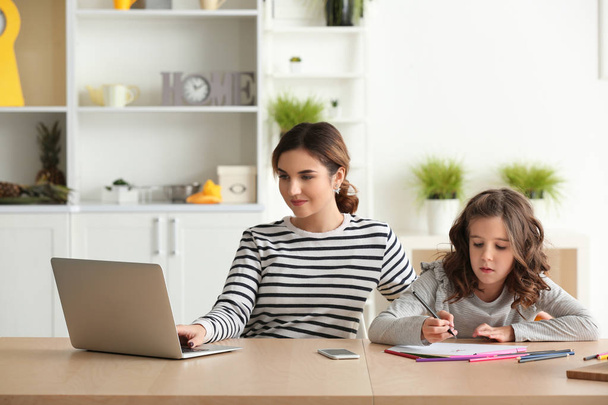 Busy mother with daughter working at home - Foto, Imagen