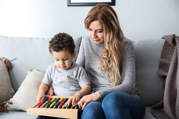 Sevimli küçük oğluyla evde abacus ile oynayan genç anne - Fotoğraf, Görsel