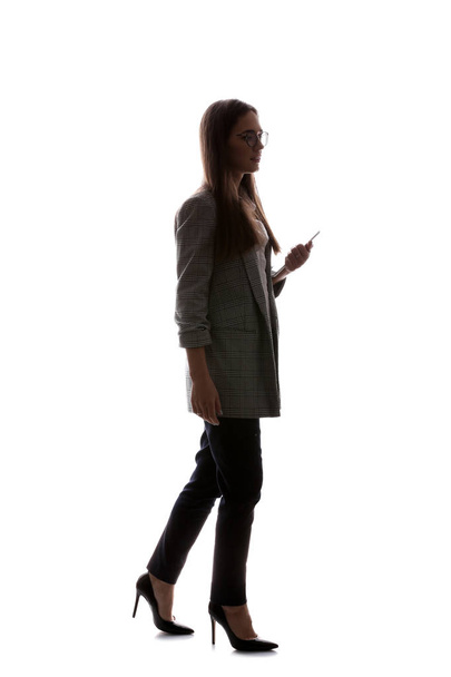 Silhouette of beautiful businesswoman with mobile phone on white background - Photo, image