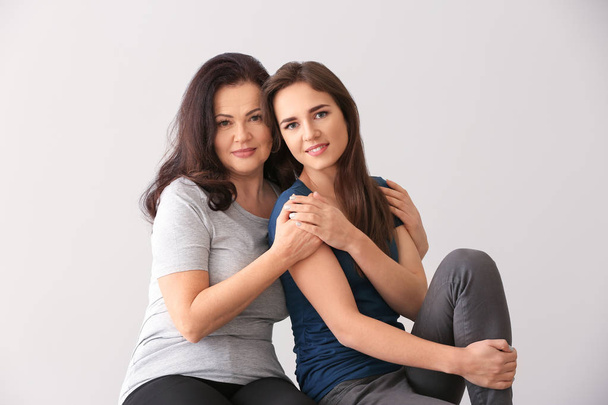 Портрет молодой женщины с матерью на светлом фоне
 - Фото, изображение