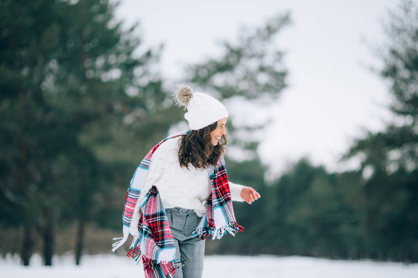 Jovem mulher se diverte e ri durante a caminhada no pinhal de inverno
. - Foto, Imagem